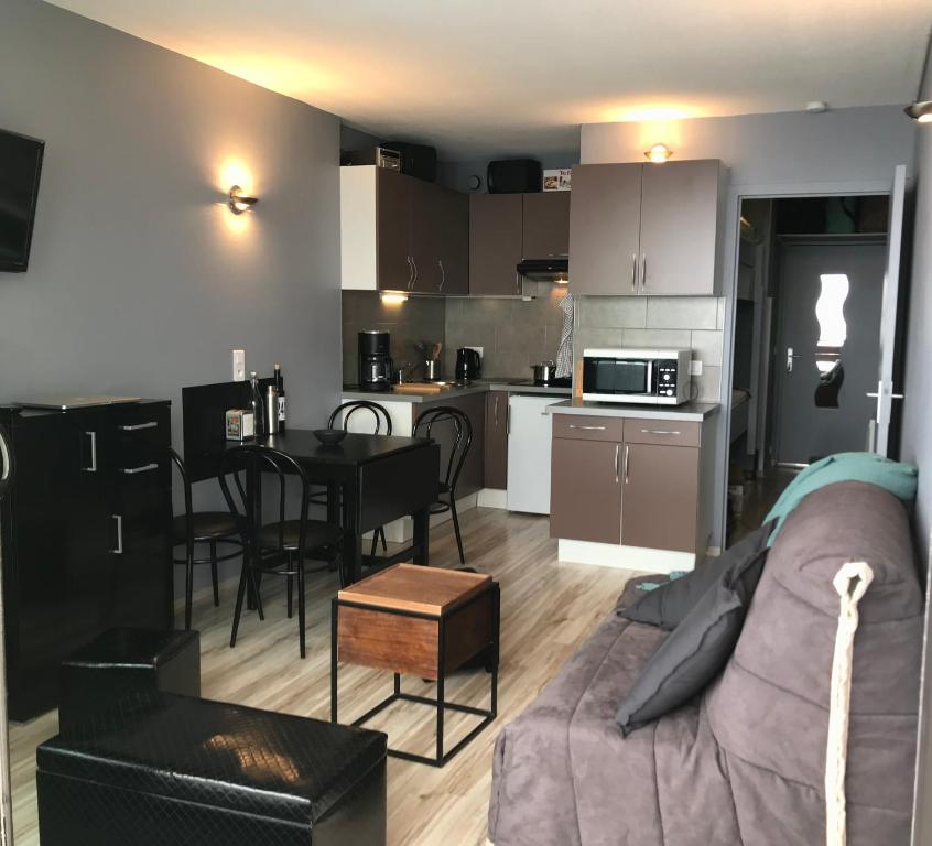 a living room and kitchen with a couch and a table at Appartement 4 personnes au pied des pistes in La Pierre Saint Martin