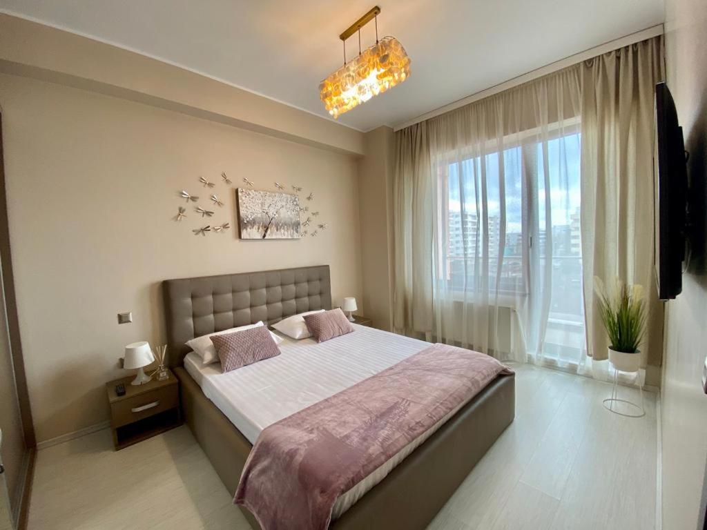 1 dormitorio con cama grande y ventana grande en Vedere la mare apartament, en Mamaia