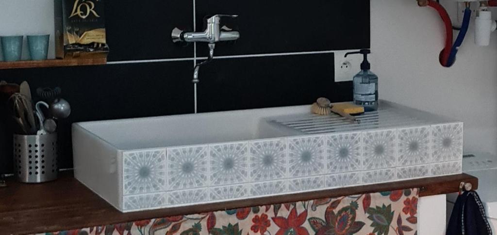 a white sink with a faucet on top of a counter at Charmant logement avec parking in Orvault