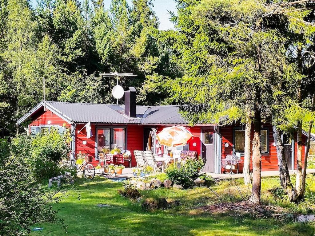 uma casa vermelha com cadeiras e um quintal em 6 person holiday home in BLID em Blidö