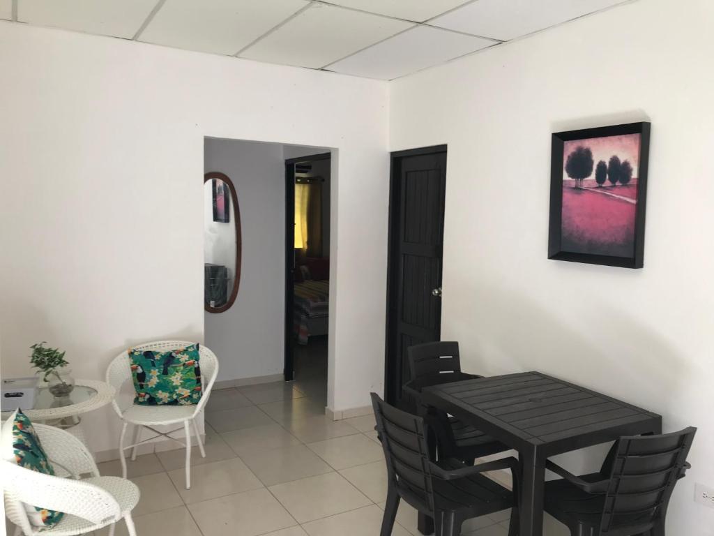 ein Esszimmer mit einem schwarzen Tisch und Stühlen in der Unterkunft Apartamentos Doña Amelia in Chitré