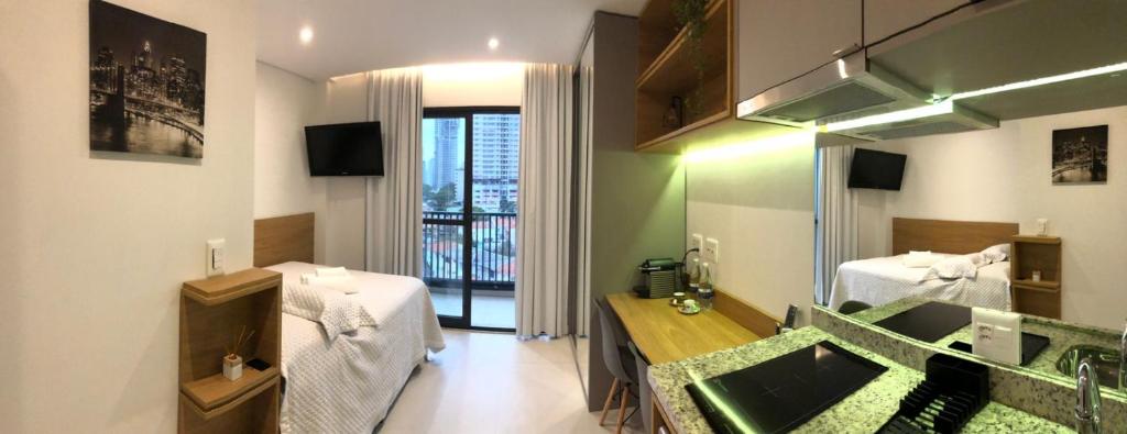 een kamer met een salon met een wastafel en een spiegel bij Brooklin Studios I Em frente ao metrô Brooklin in Sao Paulo
