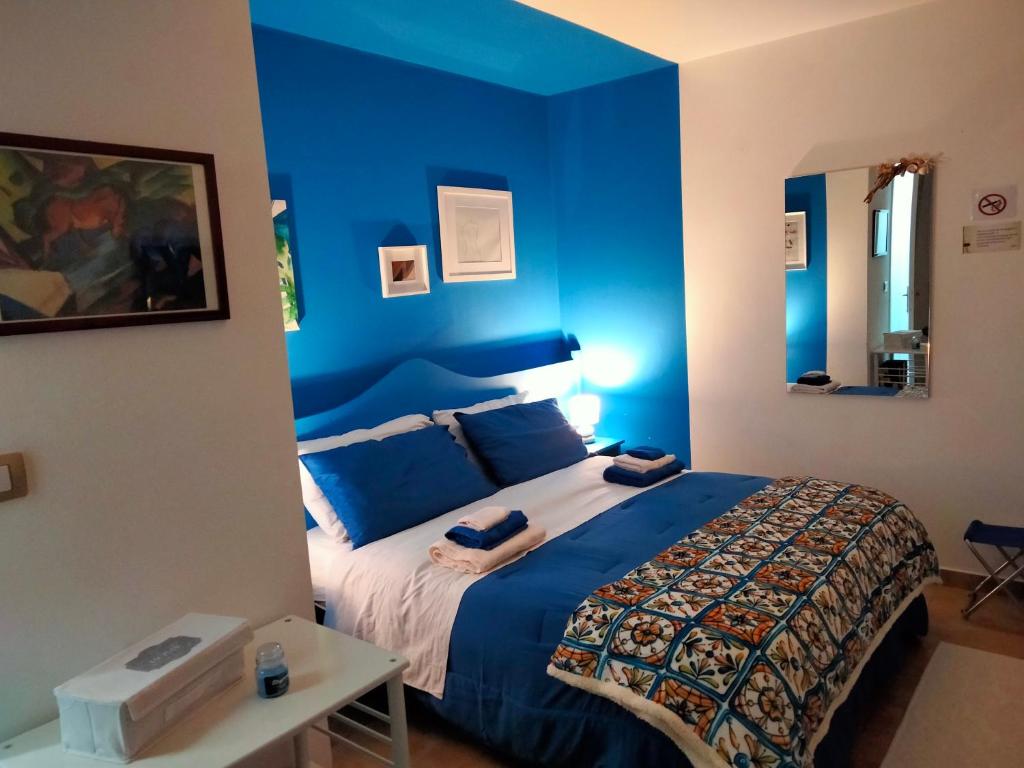 B&B Al Quindici Scilla في سيلا: غرفة نوم بجدران زرقاء وسرير في غرفة