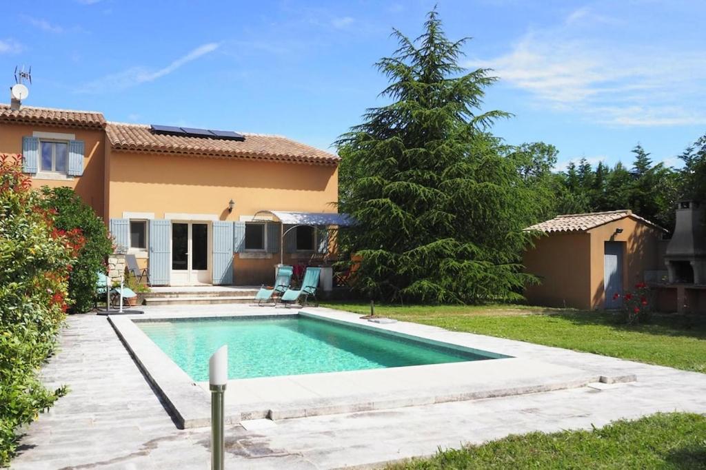 a swimming pool in front of a house at Semi-detached house, Lacoste in Lacoste