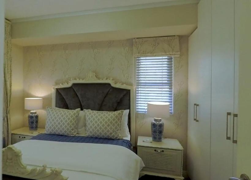 1 dormitorio con 1 cama y 2 mesitas de noche con lámparas en Century City Mayfair Luxury Apartments, en Ciudad del Cabo