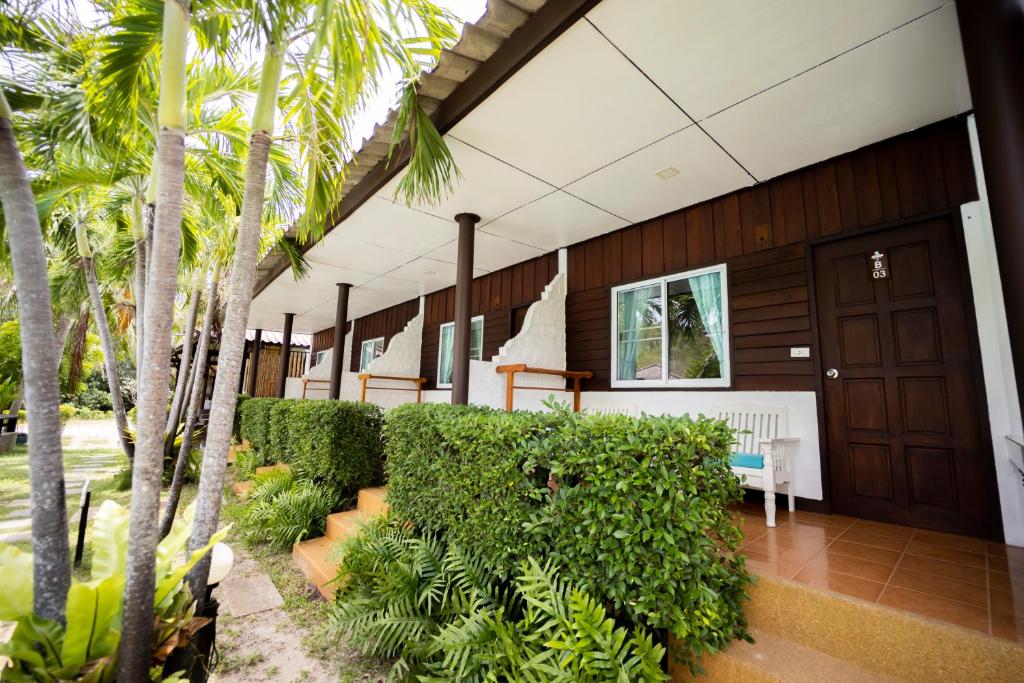 a building with a fence and palm trees at Assava Dive Resort - SHA Plus in Koh Tao