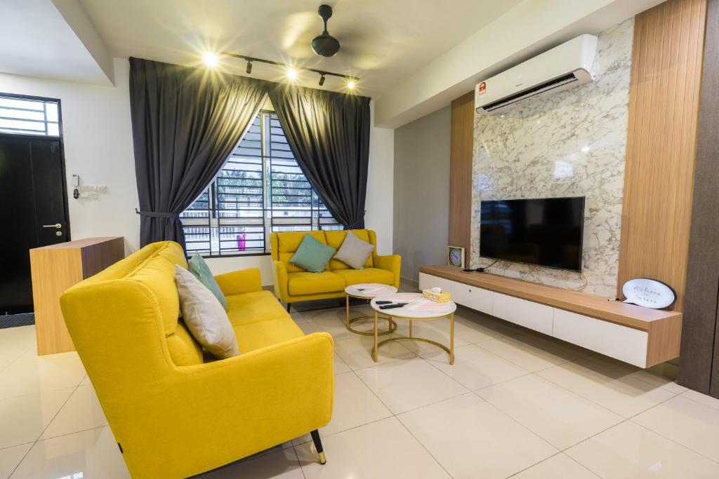 sala de estar con sofá amarillo y TV en Desaru Alpaca homestay Desaru, en Desaru