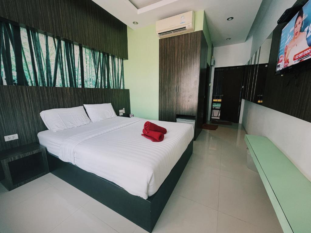 Un dormitorio con una cama blanca con una bolsa roja. en Rabeang Bann Koh Samed ระเบียงบ้านเกาะเสม็ด en Ko Samed