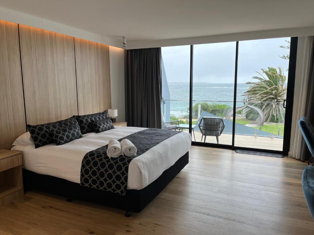 Ocean Front Motel في ذا إينترانس: غرفة نوم مع سرير وإطلالة على المحيط