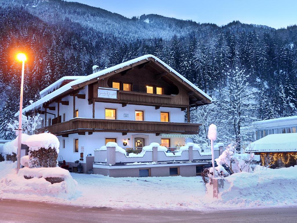 a building covered in snow with a street light at Appartements Wasserfälle in Mayrhofen