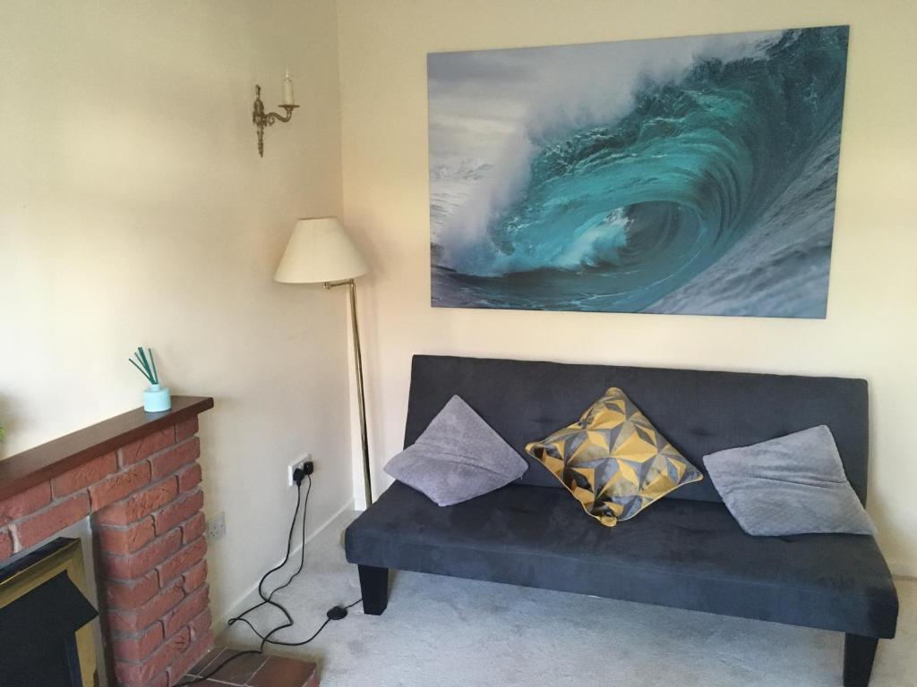 a living room with a couch and a picture of a wave at Elite Accomm Wolverhampton sleeps 4 long term workers or family comfortably in Shareshill