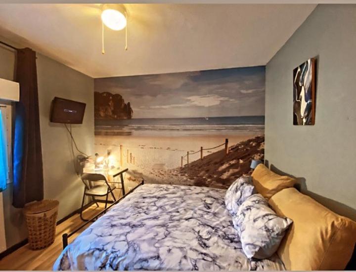 a bedroom with a bed and a painting of a beach at Chez Fanny Chambres d'hôtes in Fos-sur-Mer
