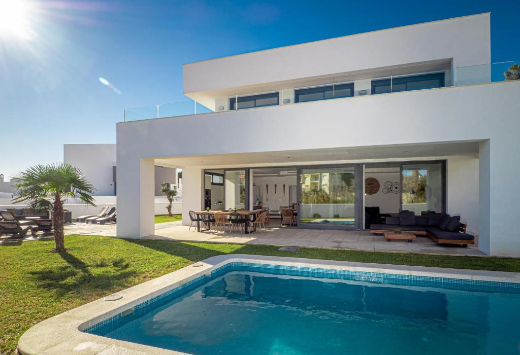 une maison avec une piscine en face de celle-ci dans l'établissement Villa moderne proche de la mer, à Manilva