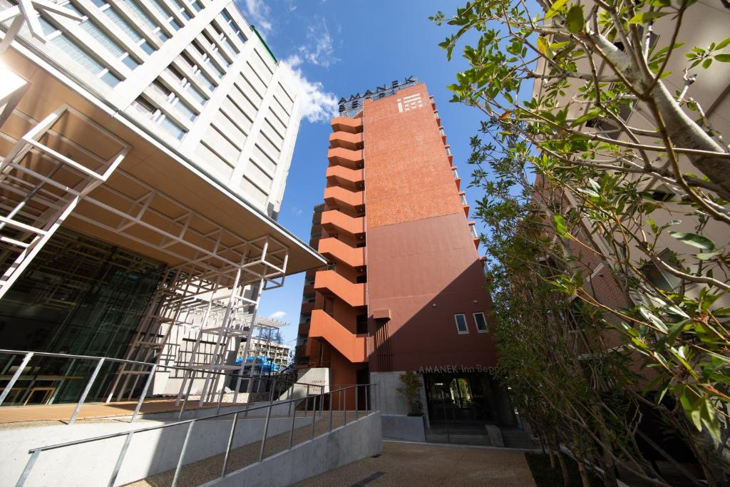 a building in the middle of some tall buildings at AMANEK Inn Beppu in Beppu