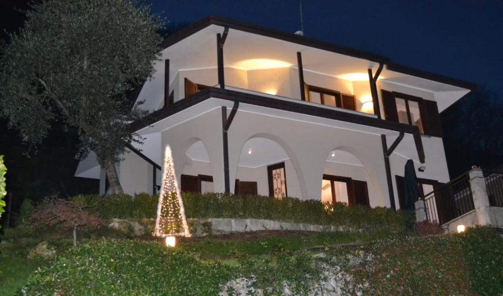 a house with a christmas tree in front of it at Le Grigne Guesthouse - The Garden in Oliveto Lario