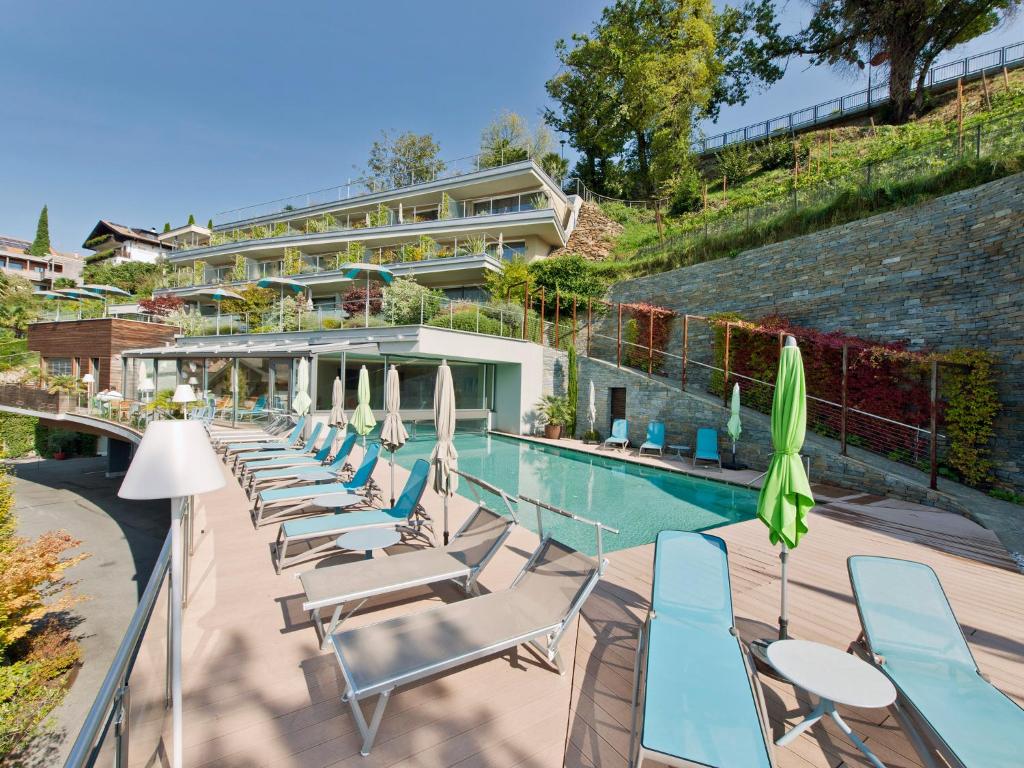 una fila de tumbonas junto a una piscina en Hotel Schennerhof, en Scena