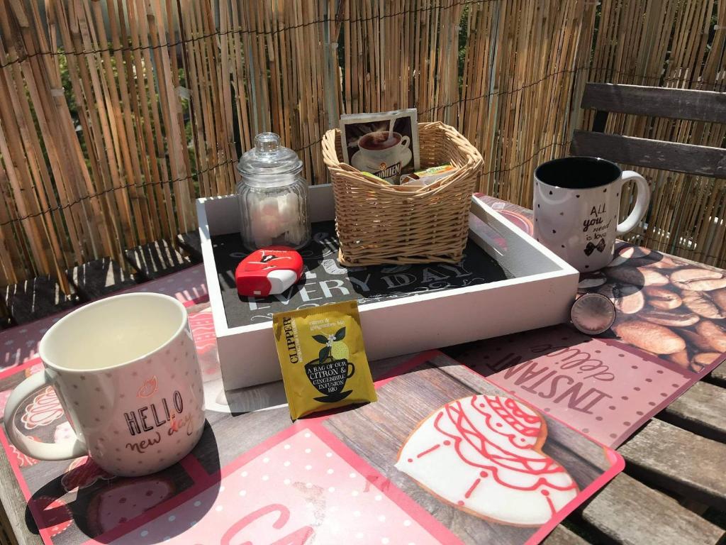 une table avec des tasses et un panier sur une table dans l'établissement 2 Pièces - Quartier Calme - Parking gratuit, à Metz