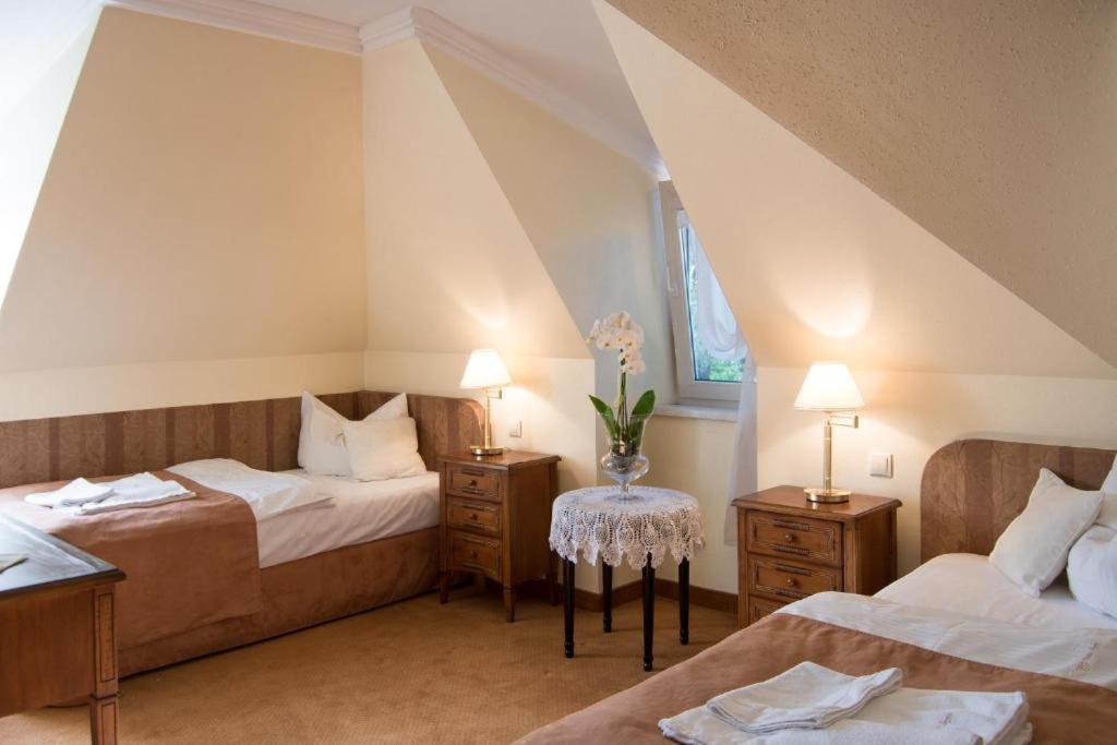 sypialnia na poddaszu z 2 łóżkami i oknem w obiekcie Villa Siesta w Zielonej Górze