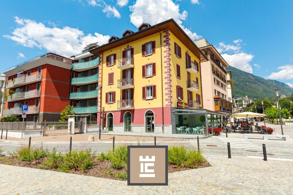 um edifício amarelo com um sinal em frente em Residenza IL CASTELLO em Sondrio