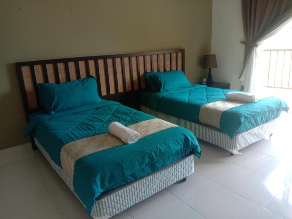 Duas camas num quarto com almofadas azuis em Izz room studio Gold Coast Morib Resort em Banting
