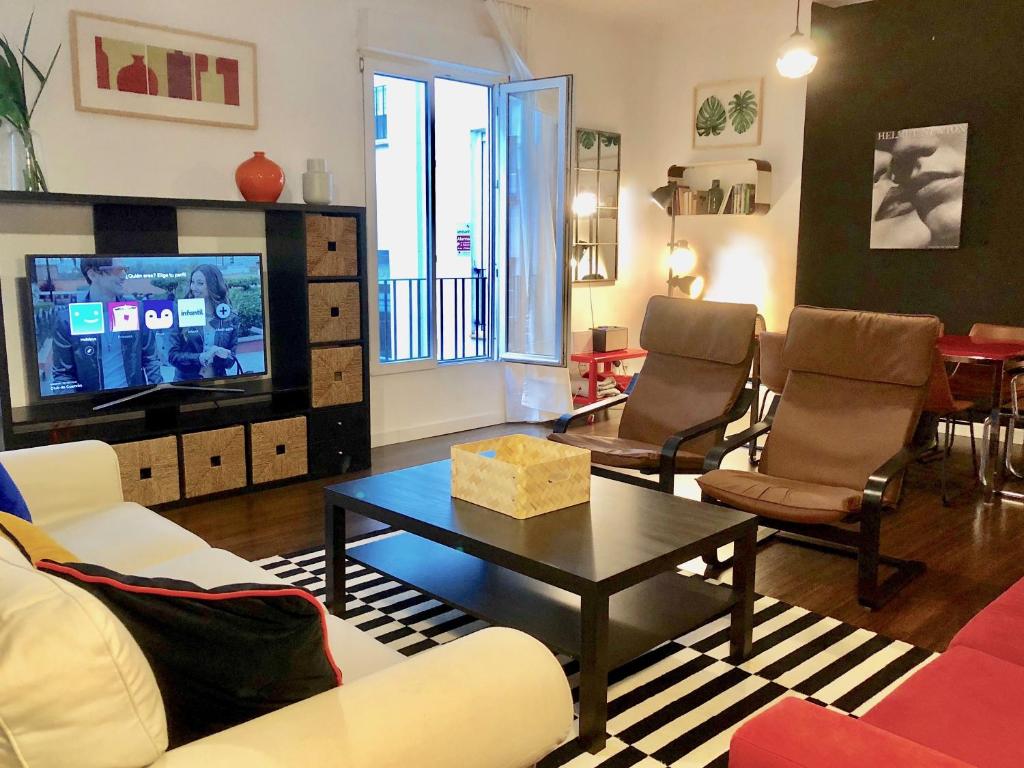 a living room with a couch and a table and a tv at Smart Plaza de las Cortes in Madrid