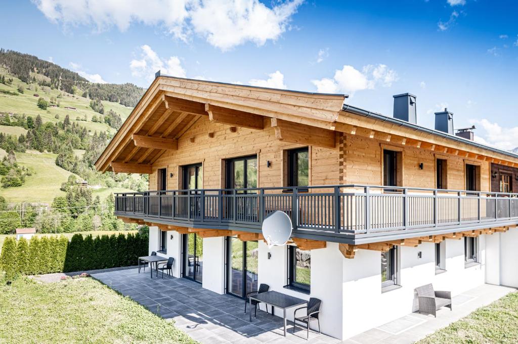 a wooden house with a deck and chairs at Ferienhaus Reiter Jochberg bei Kitzbühel in Jochberg