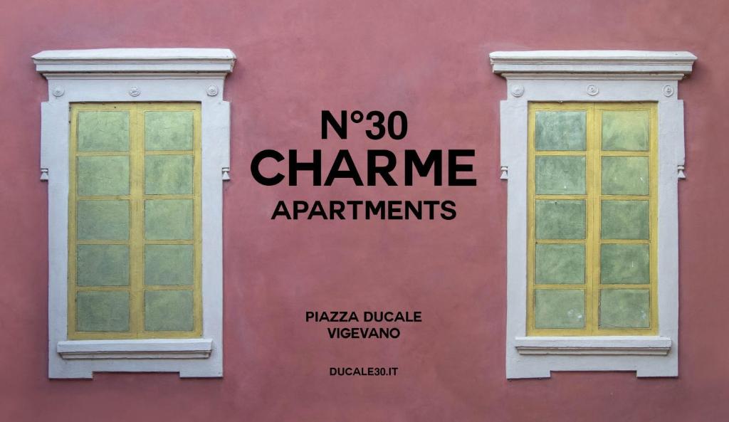 Una pared rosa con dos ventanas. en N°30 CHARME Apartments en Vigevano