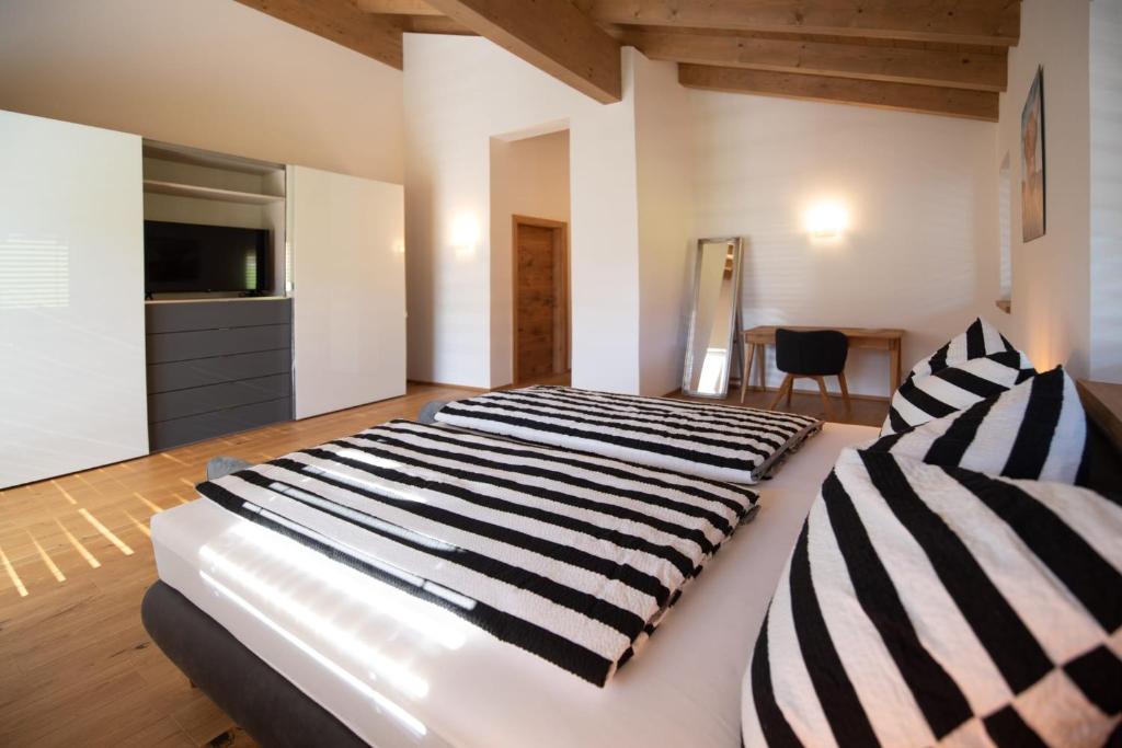 a bedroom with a large bed with black and white stripes at Ferienhaus Reiter Jochberg bei Kitzbühel in Jochberg