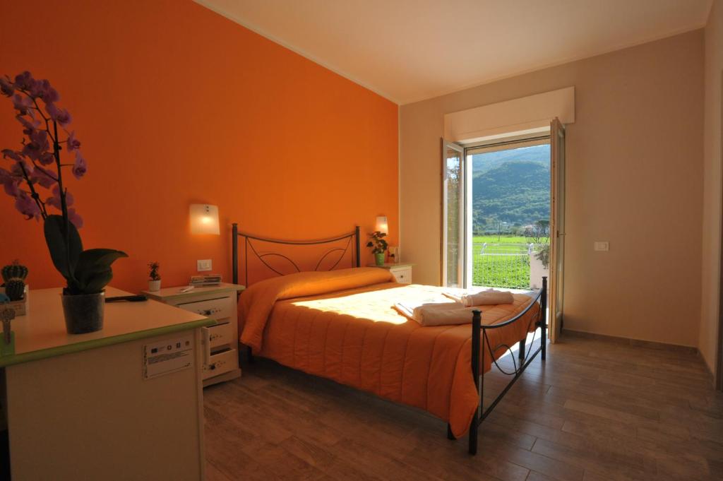 a bedroom with orange walls and a bed and a window at Agriturismo San Raphael in Capaccio-Paestum