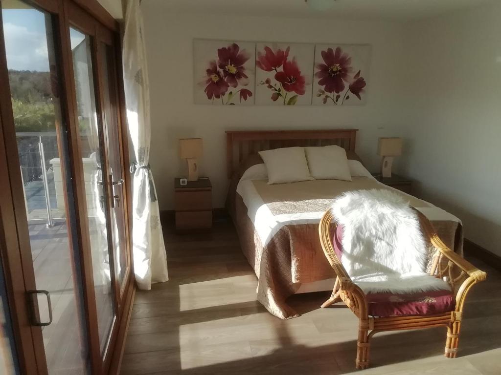 ein Schlafzimmer mit einem Bett, einem Stuhl und einem Fenster in der Unterkunft Bellevue Josselin in Josselin
