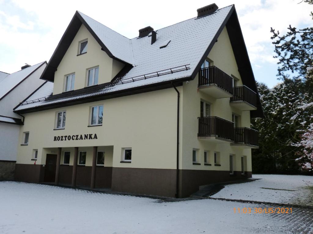 a building with snow on the ground at Willa Roztoczanka in Rabka-Zdrój