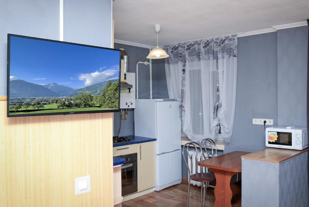 a kitchen with a flat screen tv on a wall at Apartment Pushkina in Dnipro