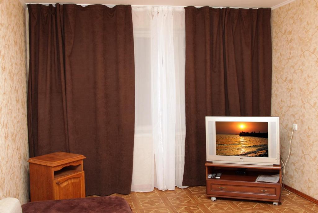 a living room with a television on a table at Pobeda Apartment in Dnipro