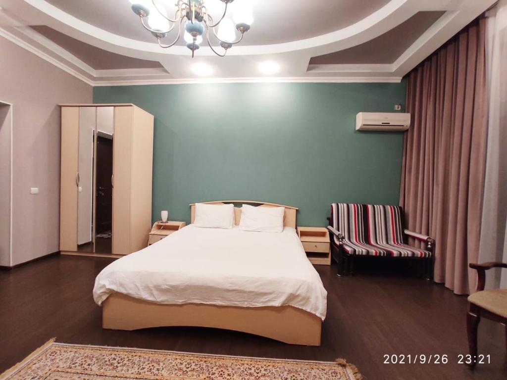 a bedroom with a bed and a green wall at Altyn in Astana