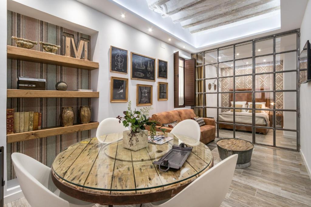 Una sala de estar con una mesa y sillas de madera. en Loft Gracia- CTH Granada, en Granada