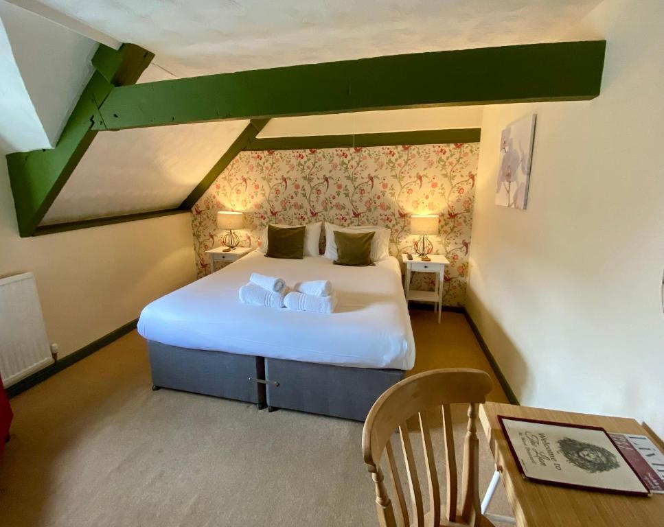 um quarto com uma cama com duas almofadas em The Lion at West Pennard em West Pennard