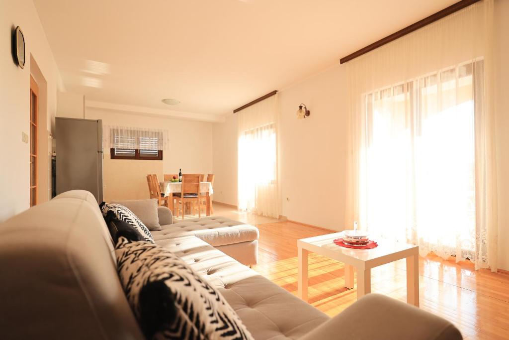 een woonkamer met een witte bank en een tafel bij Apartments Ana in Petrcane