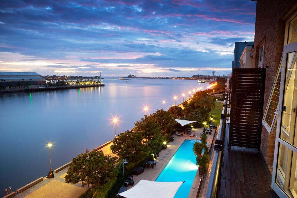 uma vista para a água à noite a partir de um edifício em Rydges Newcastle em Newcastle