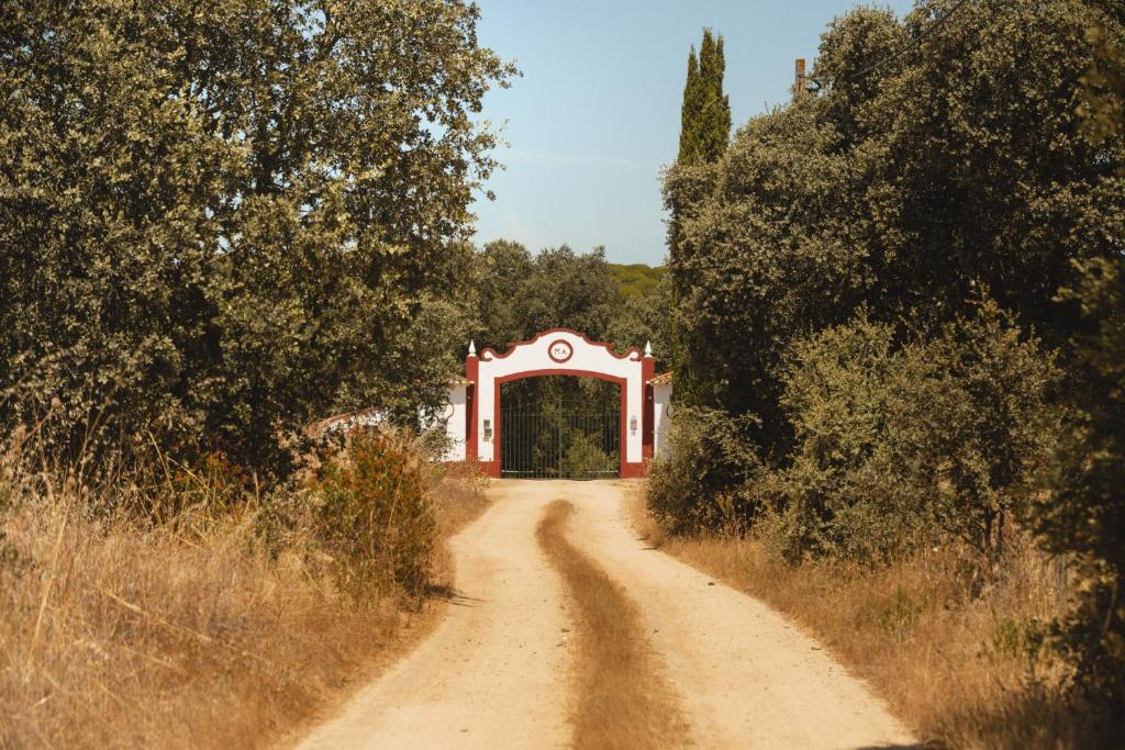 a dirt road leading to a red and white tunnel at Moinho Do Álamo in Montemor-o-Novo