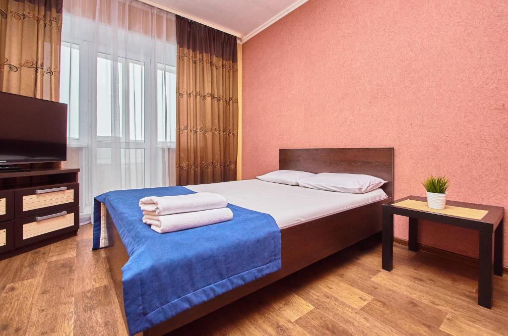 トムスクにあるКвартиры на Карла Ильмераのベッドルーム1室(タオル付)