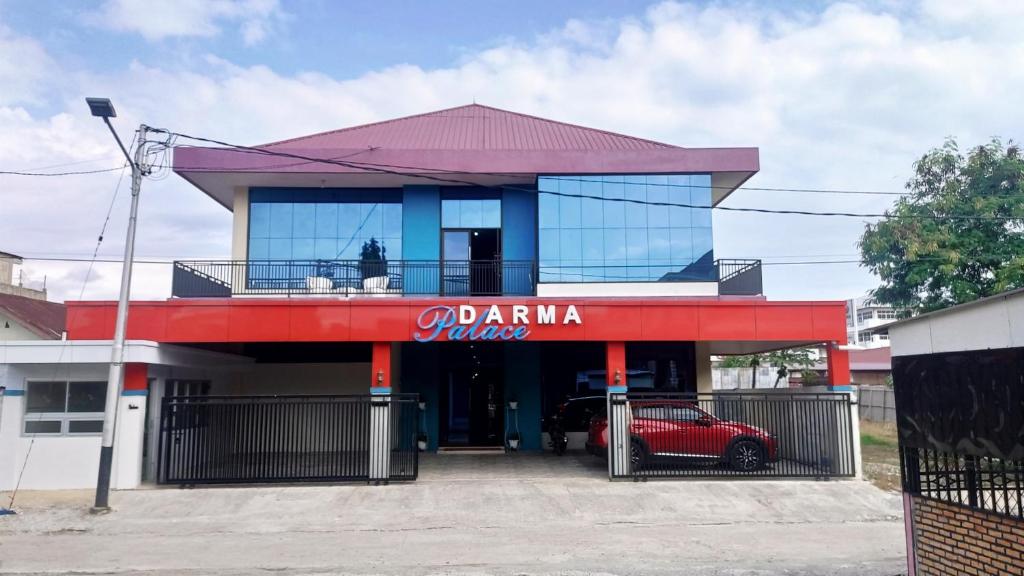 a red car parked in front of a building at Darma Palace Syariah in Padang