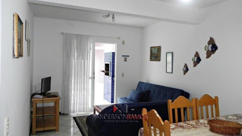 sala de estar con sofá azul y ventana en 1031 - Apartamento para locação em Bombinhas - Residencial Solar das Bromélias Apto 157, en Bombinhas