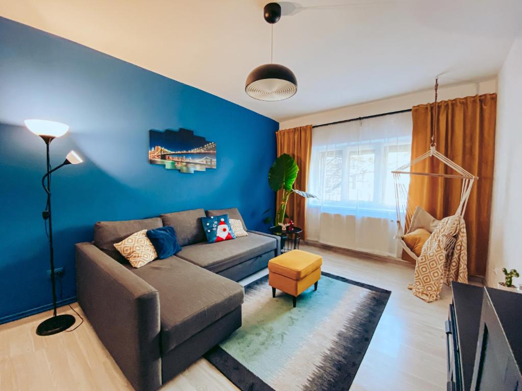 a living room with a couch and a blue wall at Apartment One Brasov in Braşov