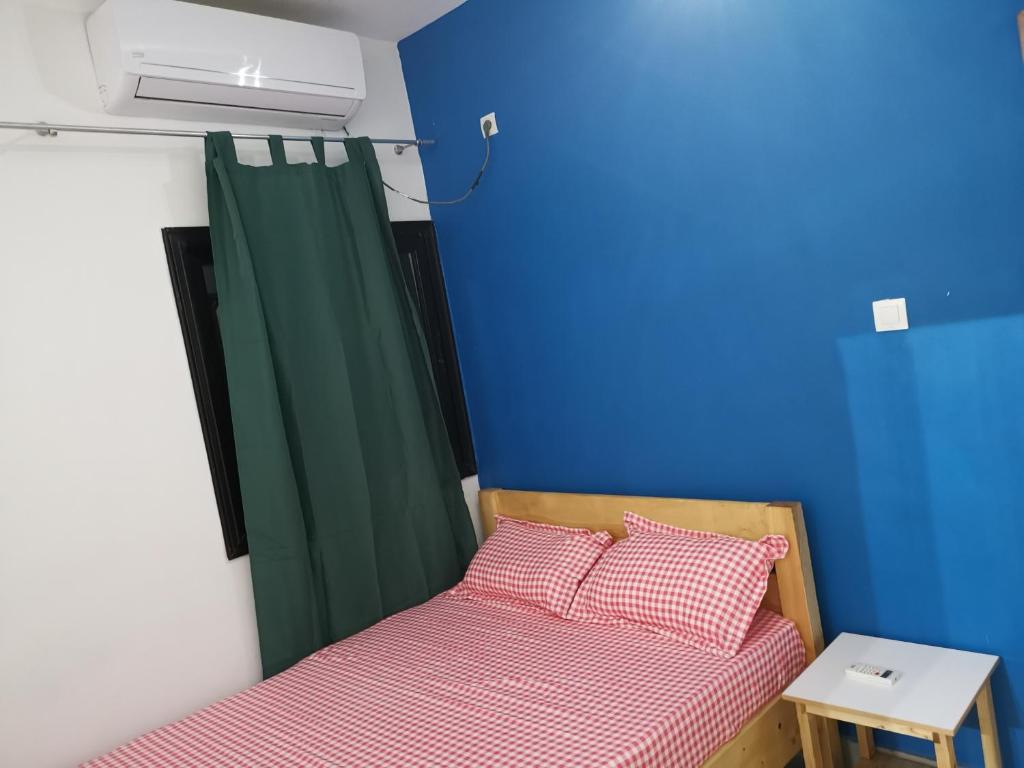 1 dormitorio con 2 camas y cortina verde en Résidence Safie, en Yof