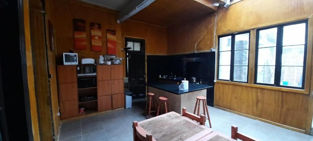 a kitchen with a table and a counter and some windows at HOSTAL PLAYA ANCHA in Valparaíso