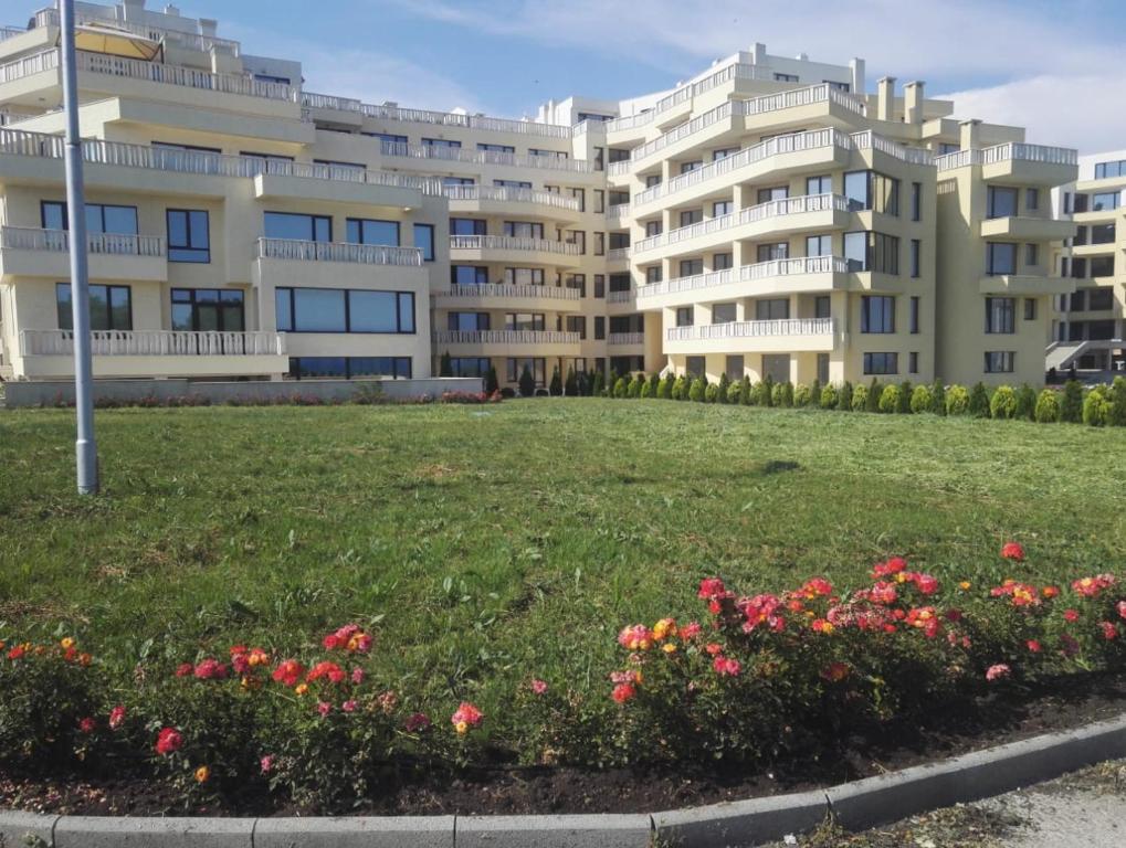 duży budynek apartamentowy z polem kwiatów w obiekcie Apartments Sarafovo w Burgas