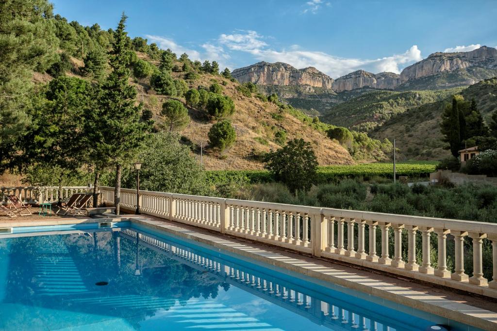 a swimming pool with a mountain in the background at El Xalet del Priorat in Escaladei