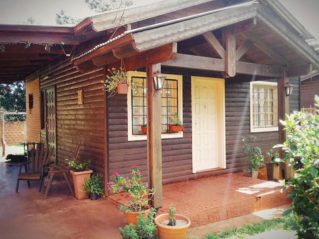 ein kleines Haus mit einer Veranda und einer Terrasse in der Unterkunft Morada Silvestre Iguazú in Puerto Iguazú