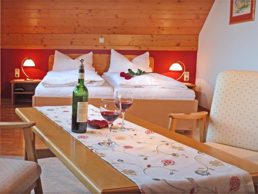 Aflenz KurortにあるHaus Lechthalerのベッド2台、テーブル(ワイングラス付)が備わる客室です。