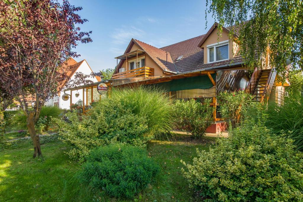 a house with a yard with bushes and trees at Füredi Apartman in Tiszafüred